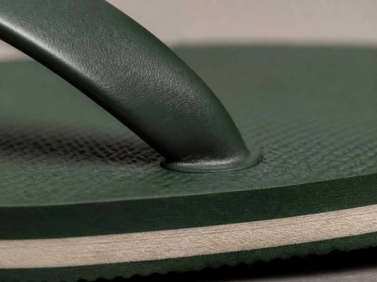 Detalhe macro do acabamento do solado de um chinelo verde